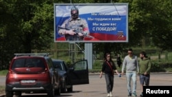 ARHIVA - Ljudi šetaju pored bilborda sa porukom podrške ruskoj vojsci, u gradu Viborgu, na obalama Finskog zaliva, u Lenjingraskoj oblasti, u Rusiji, 28. maja 2023.