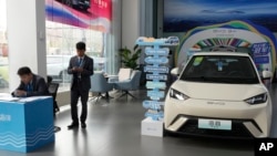 資料照片：銷售人員站在北京一家展廳內中國汽車製造商比亞迪生產的「海鷗」電動車附近。（2024年4月10日）