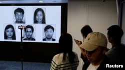 香港當局在記者會上公佈五位被通緝的身處海外的香港活動人士照片。（2023年12月14日）