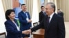 In this handout photo released by Uzbekistan's Presidential Press Office, Uzbekistan's President Shavkat Mirziyoyev greets members of an election commicion at a polling station during a referendum in Tashkent, Uzbekistan, April 30, 2023. 