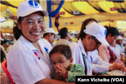 Sorn Phearum, a member of the Women's Movement of the Candlelight Party in Pursat province, carries her baby as she attends the Extraordinary Congress of the Candlelight Party in Siem Reap province, Feb. 11, 2023.