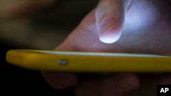 FILE - A man uses a cellphone in New Orleans on Aug. 11, 2019.
