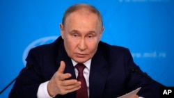 FILE - Russian President Vladimir Putin speaks at the Russian Foreign Ministry in Moscow, June 14, 2024. President Joe Biden has vowed to support Ukraine in its war with Russia “as long as it takes,” but former President Donald Trump's view of the conflict is complicated.