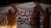 FILE - Taliban supporters hold an Islamic Emirate of Afghanistan flag during a rally in Kabul, Afghanistan, Aug. 30, 2022.