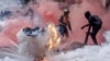 A tear gas canister explodes as protesters try to help injured people outside the Kenya Parliament during a nationwide strike to protest against tax hikes and the 2024 finance bill, in downtown Nairobi.