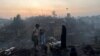 A Rohingya refugee family stands near their shelter that has been destroyed after a fire broke out in the Rohingya refugee camp in Balukhali in Cox's Bazar, Bangladesh, March 5, 2023. 