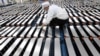 FILE - A worker works with car batteries at a factory for Xinwangda Electric Vehicle Battery Co. Ltd., which makes lithium batteries for electric cars and other uses, in Nanjing in China's eastern Jiangsu province, March 12, 2021.