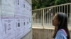 FILE - A pedestrian looks at the police reward notices for the arrest warrants issued for pro-democracy activists living in the United States, Britain, Canada and Australia for alleged national security offenses in Hong Kong, July 14, 2023. 