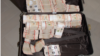 A suitcase filled with cash is shown on the website of Singapore police. In raids in mid-August, authorities seized close to three quarters of a billion U.S. dollars in assets, including more than 100 luxury condos and dozens of flashy cars.
