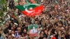 FILE - Pakistan Tehreek-e-Insaf (PTI) party supporters hold portraits of former prime minister Imran Khan as they protest against the alleged skewing in country's national election, in Peshawar, March 10, 2024. 