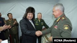 资料图：朝鲜领导人金正恩在访问俄罗斯符拉迪沃斯托克期间与时任俄罗斯国防部长绍伊古握手。（2023年9月16日）
