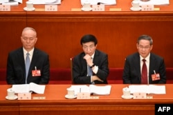 左起：中共中央政治局常委蔡奇、王滬寧（左）與李強在人大會堂出席全國人大會議。 （2023年3月7日）