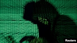Seorang peretas digambarkan sedang berusaha membobol kode cyber dalam sebuah ilustrasi. (Foto: REUTERS/Kacper Pempel)