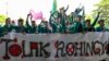 Mahasiswa memegang spanduk bertuliskan “Tolak Rohingya” saat berdemonstrasi menentang kedatangan pengungsi Rohingya di depan Dewan Perwakilan Rakyat (DPR) di Banda Aceh pada 27 Desember 2023. (CHAIDEER MAHYUDDIN / AFP)
