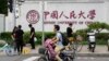 北京街頭人們經過中國人民大學校園外牆的標識。（2024年7月22日）
