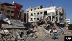 Seorang pria Palestina berjalan melewati bangunan yang hancur di Rafah di Jalur Gaza selatan pada 26 Mei 2024. (Foto: AFP)