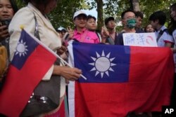 來自台灣的李洋和王齊麟贏得2024巴黎奧運羽球男雙金牌後，台灣球迷在羽球賽場Porte de La Chapelle Arena外展示台灣旗幟參加慶祝活動。（2024年8月4日）