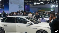 แฟ้มภาพ - ผู้เข้าชมงาน China Auto Show ในกรุงปักกิ่ง เมื่อ 26 เม.ย. 2567 แวะชมรถที่บูธบริษัท BYD (AP)