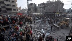 Palestinci pretražuju ruševine zgrade u potrazi za tijelima umrlih i preživjelima, nakon izraelskog vasdušnog napada, 20. decembra 2023. godine.