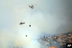 Dva helikoptera lete iznad požara u Apesiji, planinskom seu u Limasolu, jugozapadni Kipar, 7. avgusta 2023.