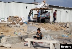 Palestinski dečak posmatra kako se ljudispremaju da pobegnu iz Rafe nakon što su izraelske snage pokrenule kopnenu i vazdušnu operaciju u istočnom delu tog južnog grada Pojasa Gaze, u Rafi, 12. maja 2024.