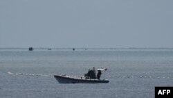 中國海警人員在南海爭議海域乘坐充氣船守在通往中國控制的黃岩島的通道上。(2023年9月22日)