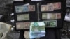 FILE - Current and pre-revolution Iranian banknotes and foreign currencies are displayed by a vendor at a commercial district in downtown Tehran, Feb. 26, 2023. 