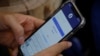 FILE - A Facebook user logs in on his mobile phone at a cafe in Hanoi, Vietnam, Nov. 19, 2020. 