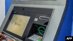Msomali akitoa pesa kutoka kwenye ATM huko Mogadishu Desemba 14,2023. Picha na Hassan Ali Elmi / AFP.