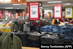 Seorang karyawan departement store menanti pelanggan di sebuah mal di Denpasar, Bali, pada 5 Mei 2023. (Foto: AFP)