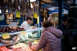 Customers purchase food in Budapest's Grand Market Hall, Hungary, April 8, 2023.