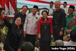 Puan Maharani berswafoto bersama dengan Ganjar Pranowo dan Mahfud MD setelah deklarasi keduanya sebagai pasangan calon presiden dan calon wakil presiden yang diusung PDI-P, di Jakarta, Rabu, 18 Oktober 2023. (Foto: Indra Yoga/VOA)
