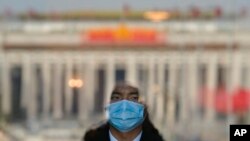 2023年3月3日，北京人民大會堂入口處，一名扮成迎賓員的安保人員站在門口。
