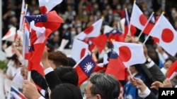 台灣與日本的國會議員在台北參加雙十節慶典時揮舞台灣與日本旗幟。 （2022年10月10日）