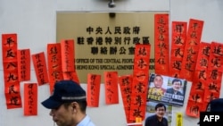2019年1月29日，警方在香港“中聯辦”外走過支持被監禁的中國人權律師王全璋的標語牌。 （法新社照片）