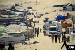 Warga Palestina yang mengungsi berjalan di tengah tenda-tenda di kota Rafah, Jalur Gaza selatan, hari Jumat 31 Mei 2024.