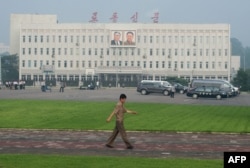 평양 시내에서 한 북한 주민이 '노동신문' 문구가 새겨진 건물 앞을 지나가고 있다. (자료화면)