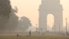 Orang-orang berolahraga di halaman rumput dekat Gerbang India di sepanjang 'Jalur Kartavya' pada pagi yang berkabut di New Delhi, India, 27 Oktober 2023. (Foto: REUTERS/Anushree Fadnavis)