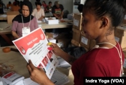 Petugas memeriksa surat suara untuk pemilihan calon presiden dan wakil presiden di Gudang KPU Kotamadya Jakarta Timur pada Kamis (11/1) di Jakarta. (VOA/Indra Yoga)