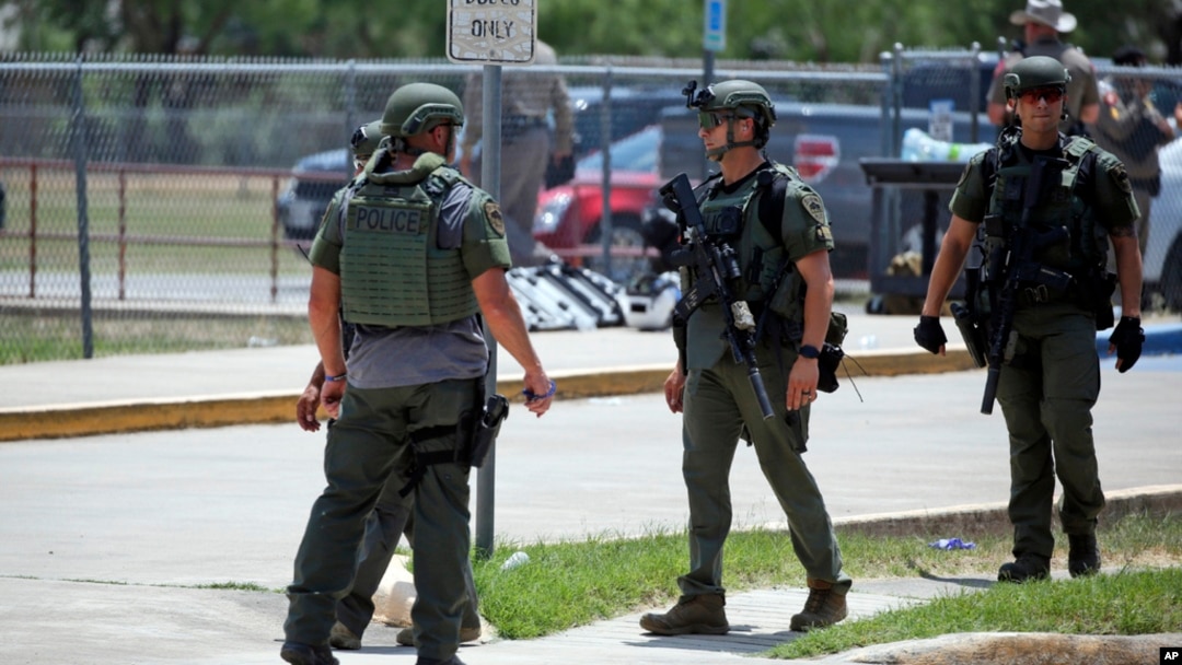 FILE — Law enforcement personnel stand outside Robb Elementary School following a shooting, May 24, 2022, in Uvalde, Texas.