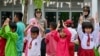Polisi wanita dari Mapolrestabes Batam bersama siswi SD saat acara "trauma healing" karena banyak siswi yang menolak bersekolah usai bentrok antara warga dan aparat keamanan terkait rencana pemerintah mengembangkan sekolah, 18 September 2023. (Bay ISMOYO / AFP).