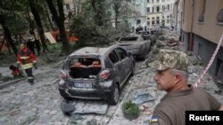 Spasioci na mestu ruskog raketnog napada na stambenu zgradu u Lavivu, Ukrajina, 6. jula 2023.