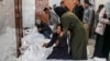 Relatives of Palestinians killed in an overnight Israeli bombardment mourn over their bodies at the European hospital morgue in Khan Younis, in the southern Gaza Strip, March 5, 2024.