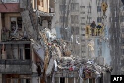 Spasioci čiste ruševine višespratnice teško oštoćene u udaru drona, u Odesi, 3. marta 2024, tokom ruske invazije na Ukrajinu.