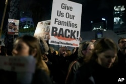 Seorang pria memegang tanda yang menyerukan pembebasan sandera yang dibawa oleh militan Hamas ke Jalur Gaza selama demonstrasi di Hostages Square di Tel Aviv, Israel, 13 Januari 2024. (Foto: AP)