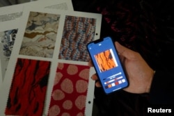 Seorang peneliti mendemonstrasikan fitur Tekstil Cerdas, yang memungkinkan pemakainya mengekstrak warna menggunakan foto ponsel dan memproyeksikannya ke bahan tersebut, di laboratorium mereka di Hong Kong, China, 5 Juni 2023. (REUTERS/Joyce Zhou)
