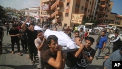 Palestinci nose tela članova porodice Abu Raješ, ubijenih u izraelskom granatiranju, tokom sahranje u Rafai, Pojas Gaze, 12. oktobra 2023.