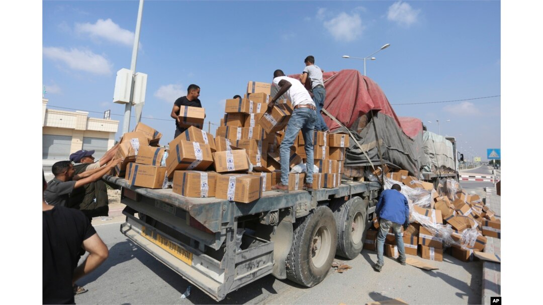 Palestinians pull aid from a truck near the Rafah border crossing in the Gaza Strip, Nov. 2, 2023.