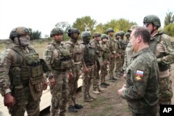 Arhiva - Zamenik predsedavajućeg ruskim Savetom bezbednosti, Dimitri Medvedev, razgovara sa pripadnicima ruske vojske tokom posete kampu za obuju u regionu Donjecka, delu Ukrajine pod ruskom kontrolom, 15. septembra 2023.
