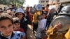 Anak-anak pengungsi Palestina antre sambil membawa panci dan wajan saat para sukarelawan membagikan makanan hangat di Khan Yunis di Jalur Gaza selatan, 23 November 202. (Mahmud HAMS/AFP)